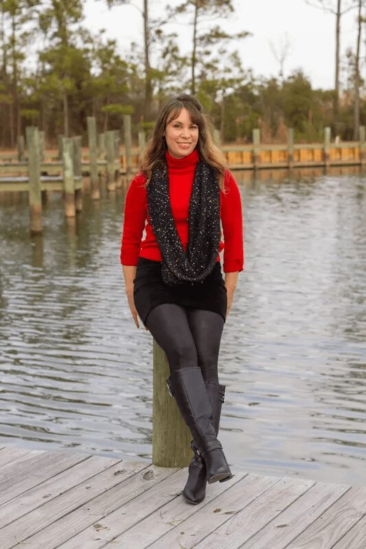 A woman sitting on top of a wooden post.