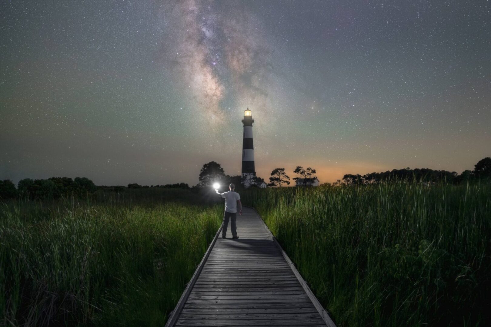 A person standing on a wooden walkway with a light