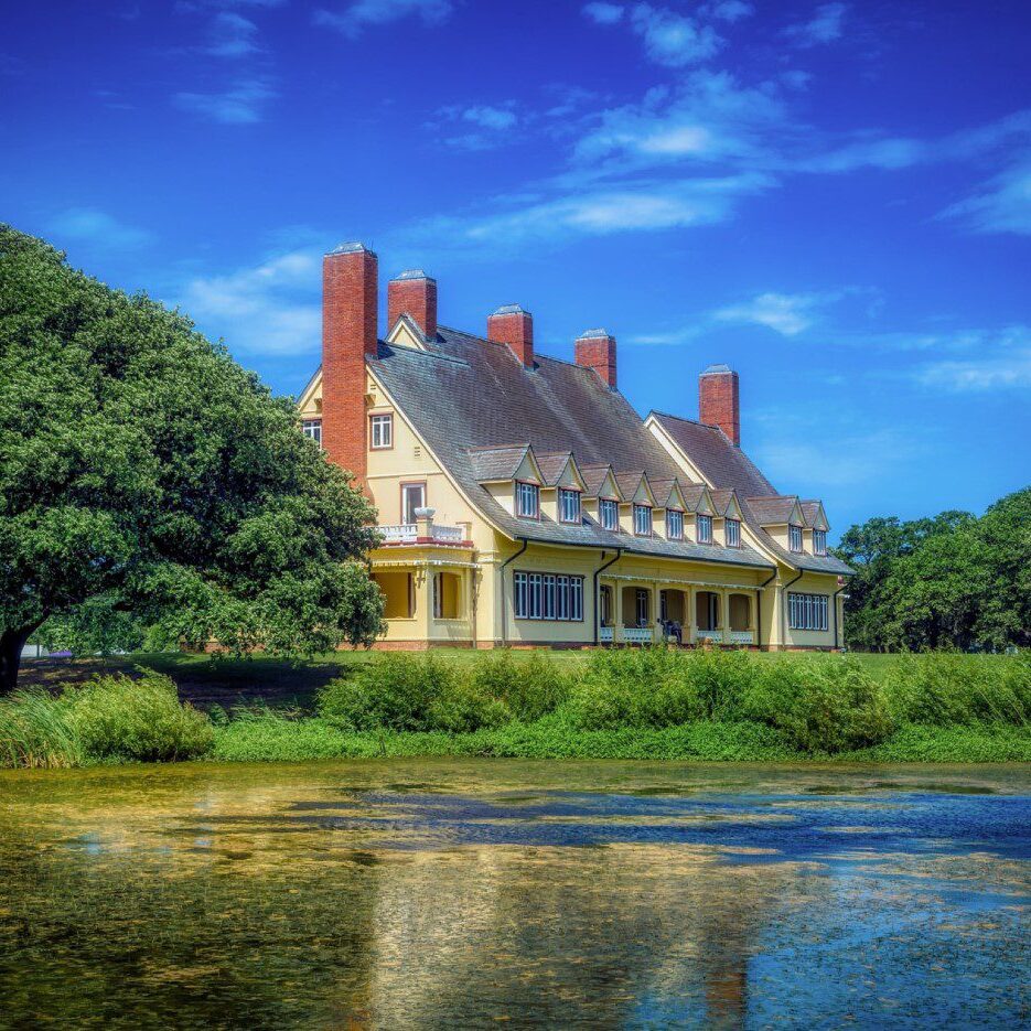 A large house with a pond in front of it
