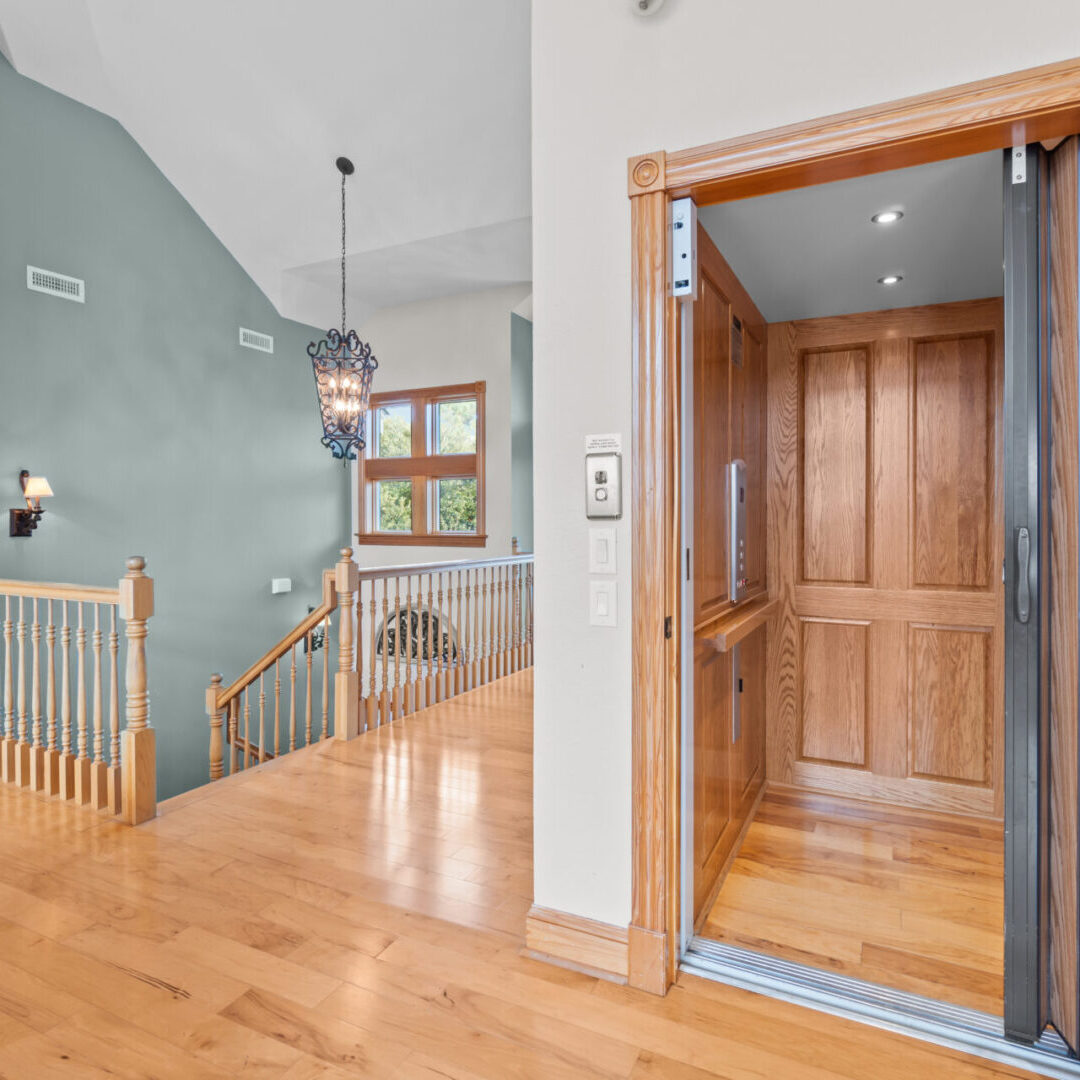 Open wood-paneled elevator at upstairs landing