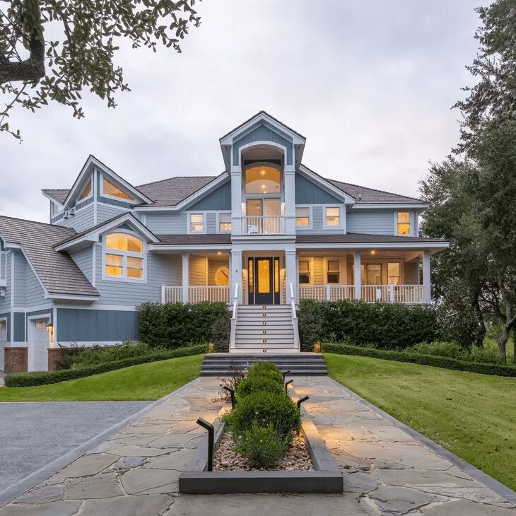 A large house with a fountain in the front yard.